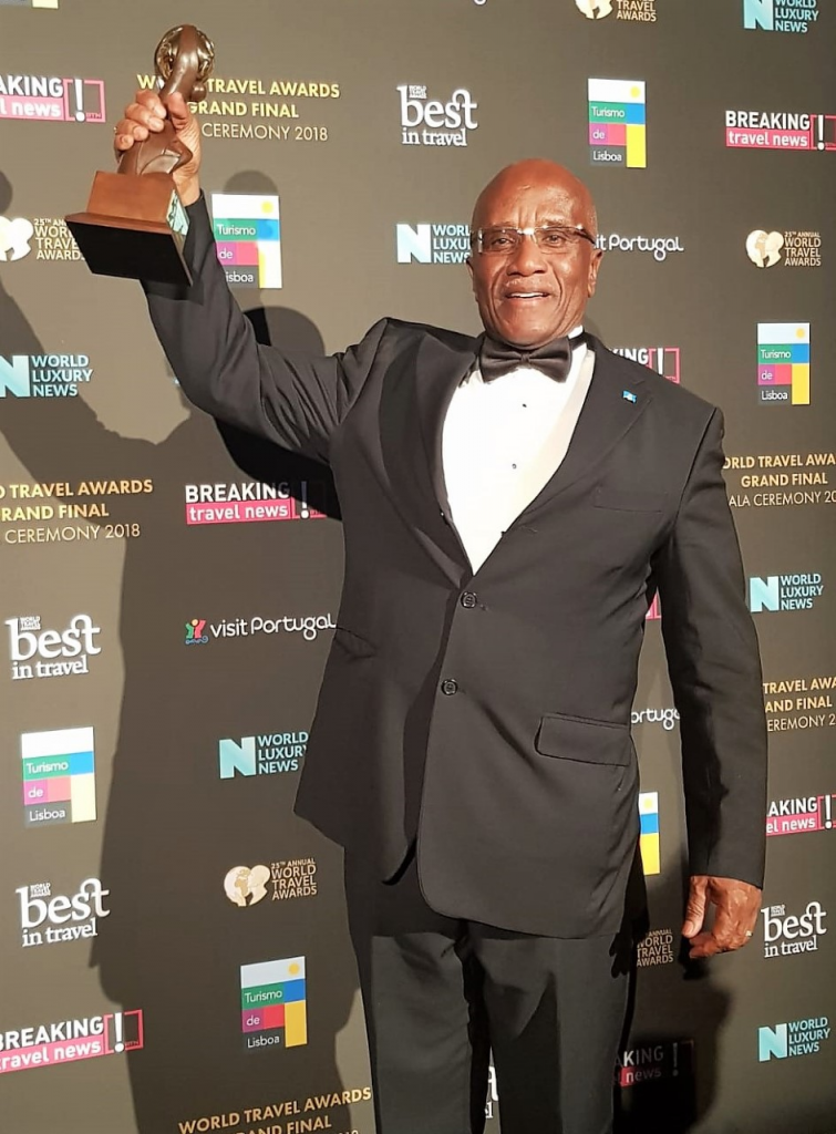 Chairman of the Saint Lucia Tourism Authority, Mr. Nicholas John, holds up the award.