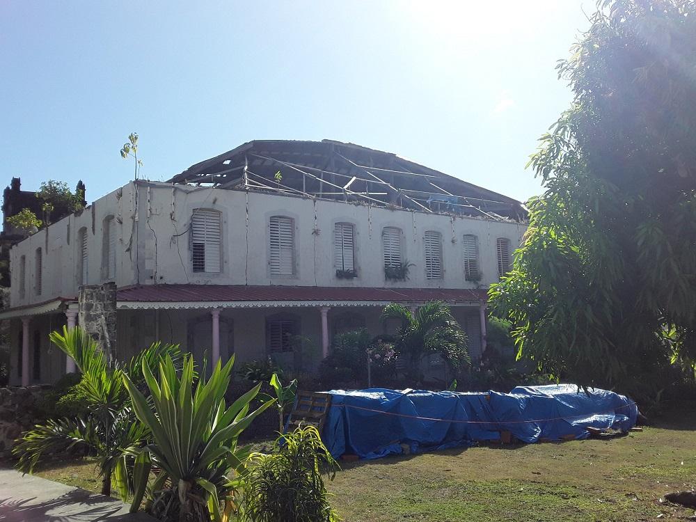 Showing nearly 3/4 of the roof stripped away by Hurricane Maria.