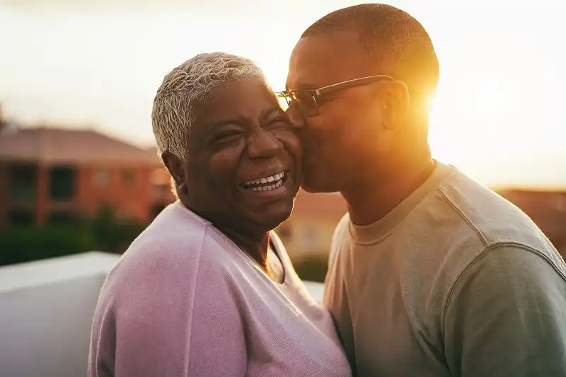 Son Kissing Grandmother on Face